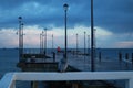 Pier on the sea. The dove sits on the pier. Cloudy cloudy weather. Birds on the sea. Baltic Sea. Many lanterns on the pier.