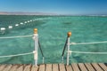 Pier in the sea in resort. Summer vacation. View at a clear sea with turquoise water. Summer vacation at a sea coastline in a exot