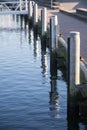 Pier shore at the marina with wooden bollards and blue sea, vert