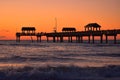 Pier 60 with silhouettes of people and waves on the coast on sunset colorful background at Cl