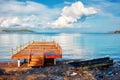 Pier and a stranded boat wreck beached on the sea shore Royalty Free Stock Photo