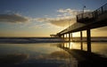 Pier in the sunset with reflections on the shore Royalty Free Stock Photo