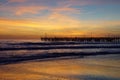 Pier in the sunset with reflections on the shore Royalty Free Stock Photo