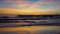 Pier in the sunset with reflections on the shore Royalty Free Stock Photo