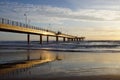 Pier in the sunset with reflections on the shore Royalty Free Stock Photo