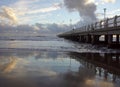 Pier in the sunset with reflections on the shore Royalty Free Stock Photo