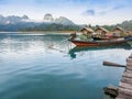 Pier with a traditional fishng boat on lake Cheow Lan, Thailand