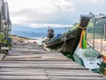 Pier with a traditional fishng boat on lake Cheow Lan, Thailand