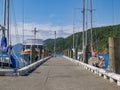 Pier on waterfront lined on either side by moored boats Royalty Free Stock Photo