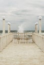 Pier with white wooden handrails at sea during a storm. Royalty Free Stock Photo