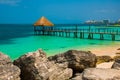 Pier and wooden gazebo by the beach. Tropical landscape with Jetty: sea, sand, rocks, waves, turquoise water. Mexico, Cancun