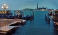 Pier with wooden landing stage and gondolas in the Venetian near square San Marco. Saint George Major`s Island in the background.