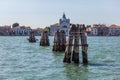 Pier wooden poles tightened together by rusty chains on canal in Venice Royalty Free Stock Photo