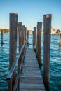 Pier wooden poles tightened together by rusty chains on canal in Venice Royalty Free Stock Photo