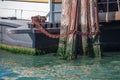 Pier wooden poles tightened together by rusty chains on canal in Venice Royalty Free Stock Photo