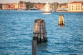 Pier wooden poles tightened together by rusty chains on canal in Venice Royalty Free Stock Photo