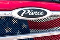 Pierce logo and a patriotic flag on front grill of the red fire engine