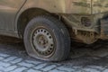 Pierced flat tire on an old abandoned rusty car Royalty Free Stock Photo