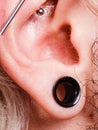 Pierced man ear, black plug tunnel, industrial and rook Royalty Free Stock Photo