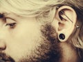 Pierced man ear, black plug tunnel, industrial and rook Royalty Free Stock Photo