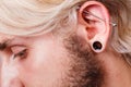 Pierced man ear, black plug tunnel, industrial and rook Royalty Free Stock Photo