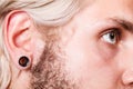Pierced man ear, black plug tunnel Royalty Free Stock Photo