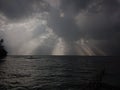 A piercing glimmer of light from the dark clouds into the Lake Maninjau