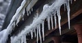 Piercing Icicles and Snow Piles Cling to a Gray Roof, Complementing a Ceiling Lamp and Stone Wall Royalty Free Stock Photo