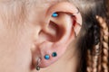piercings on an ear. Conch and helix piercings close up. Royalty Free Stock Photo