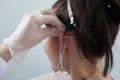 piercings on an ear. Conch and helix piercings close up. Professional holding the jewel.