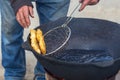 Pies are fried in a large cauldron on the fire Royalty Free Stock Photo