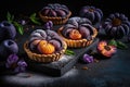 pies with purple plum baked in thin tartlet shells on dark background