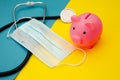 Pig moneybox, face mask and stethoscope on colorful background. Spending money on pills and expensiveness of medicine