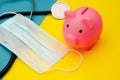 Pig moneybox in pink color, face mask and stethoscope on colorful background. Spending money on pills and expensiveness