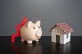 Pig piggy bank with a red arrow up and a house. Royalty Free Stock Photo
