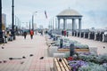 Pigeons on the city embankment. A promenade with a rotunda gazebo in the background in blur.