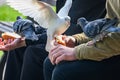 Pigeons eats white bread sitting in the arms of a teenager in the park
