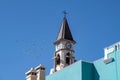 Pigeons in flight from the clock tower of the chapel of Nuestra Senora de Bonanza in El Paso, La Palma, Canary Islands, Spain