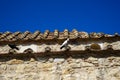 Pigeons on terracotta roof tile of old classic little church in earth tone natural stone wall with clear blue sky background Royalty Free Stock Photo