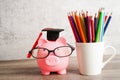 Pigging bank wearing eyeglass with coins and calculator saving bank education concept Royalty Free Stock Photo