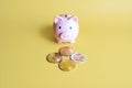 Piggy bank and Bitcoin, XRP, Dogecoin, Ethereum cryptocurrency coins on yellow background