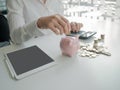 Piggy bank and business women depositing coins for saving. coins