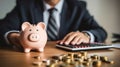 piggy bank with businessman and calculator and coin on wood table. Saving money wealth and financial concept. Business, finance, Royalty Free Stock Photo