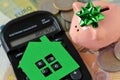 Piggy bank with calculator and paper house on euro money background - Concept of saving money to buy a home and money bonus Royalty Free Stock Photo