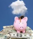 Piggy bank cash with graduation cap and blue sky