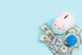 Piggy bank and cash money one hundred dollars bills on blue background. Flat lay, top view, overhead, mockup, template. Concept of Royalty Free Stock Photo