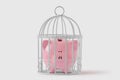 Piggy bank closed in a cage on white background - Concept of economy and savings Royalty Free Stock Photo