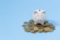 Piggy bank and coins on the blue background. Saving investment budget wealth business retirement, financial, money, banking Royalty Free Stock Photo