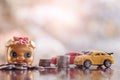 Piggy bank with coins and cars on wooden table