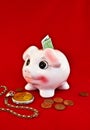 Piggy bank, coins and watch on a red background. Royalty Free Stock Photo